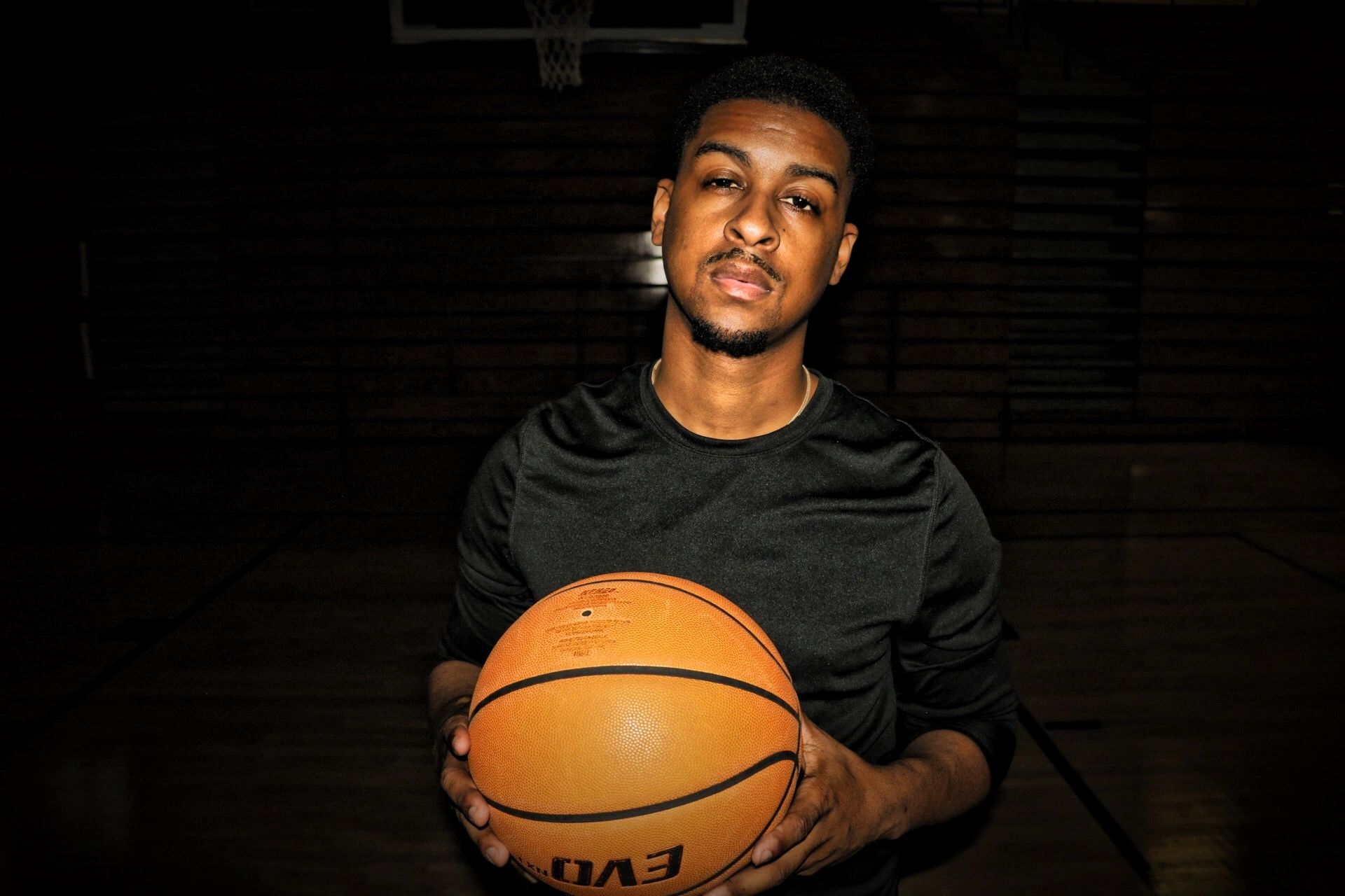 Portrait of Coach Howard holding a basketball in a gym